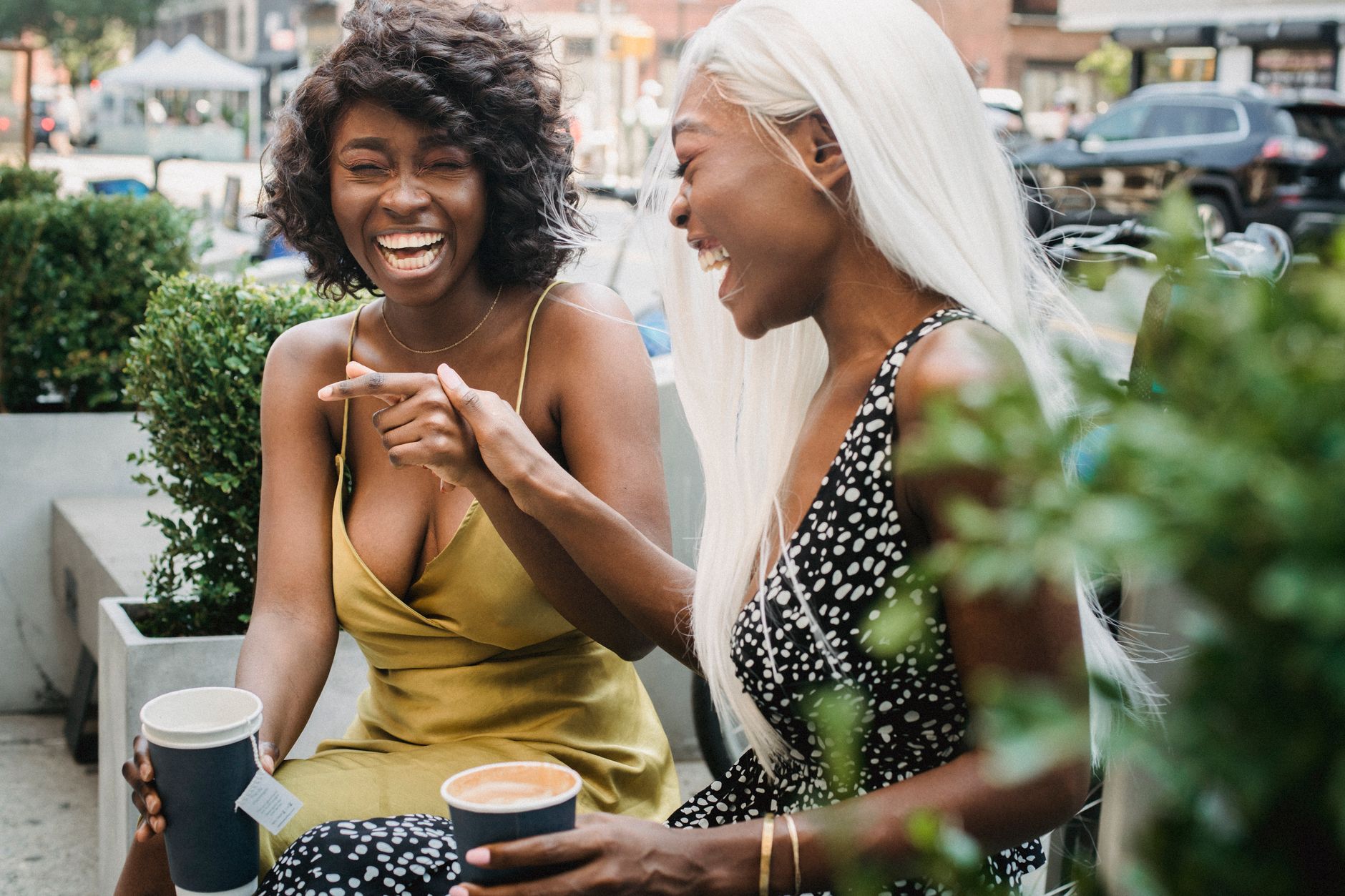 Two women friends talking and laughing together at a cafe