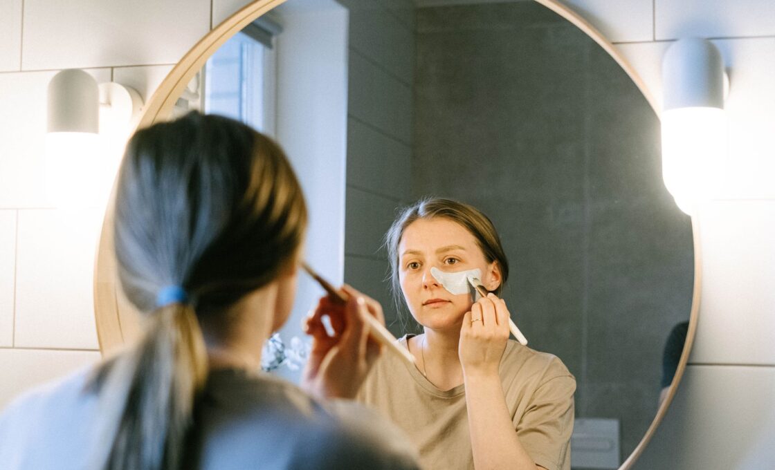 Woman applying moisturizer as part of an evening skincare routine