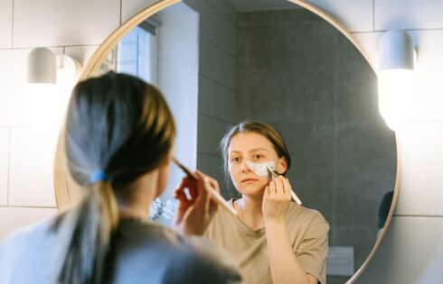 Woman applying moisturizer as part of an evening skincare routine