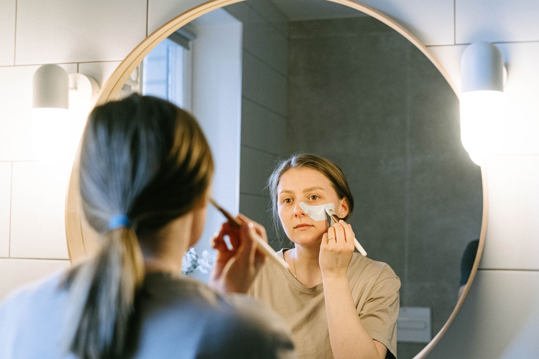 Woman applying moisturizer as part of an evening skincare routine