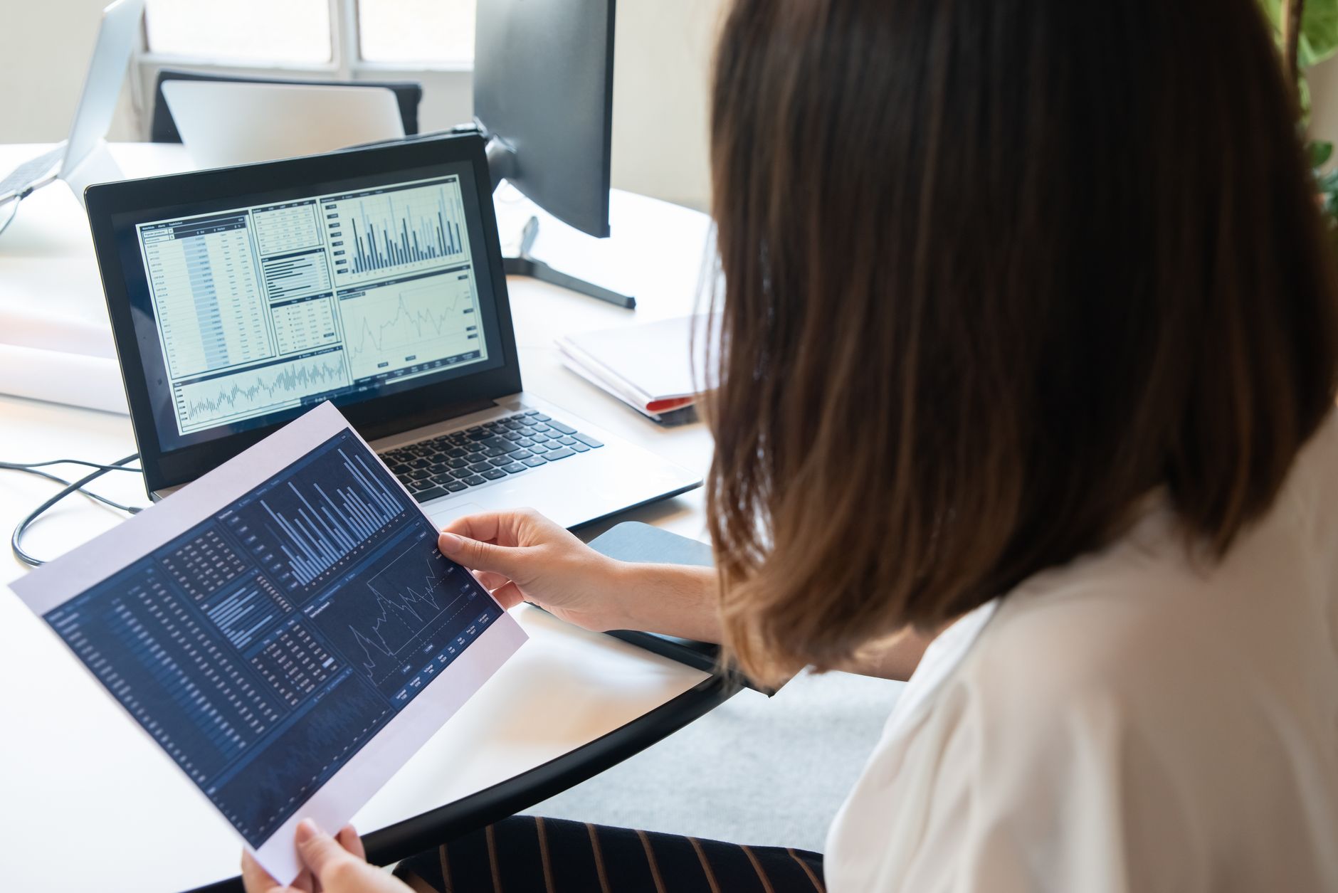 Woman reviewing investment accounts on a laptop at home