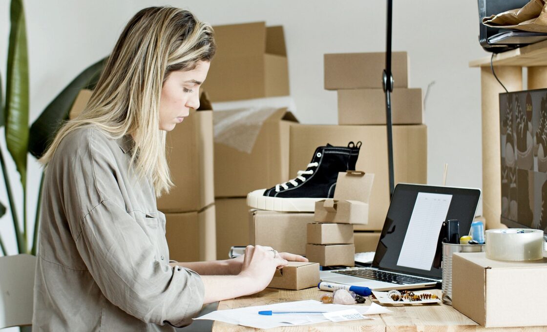 Woman at home with shopping packages and a laptop