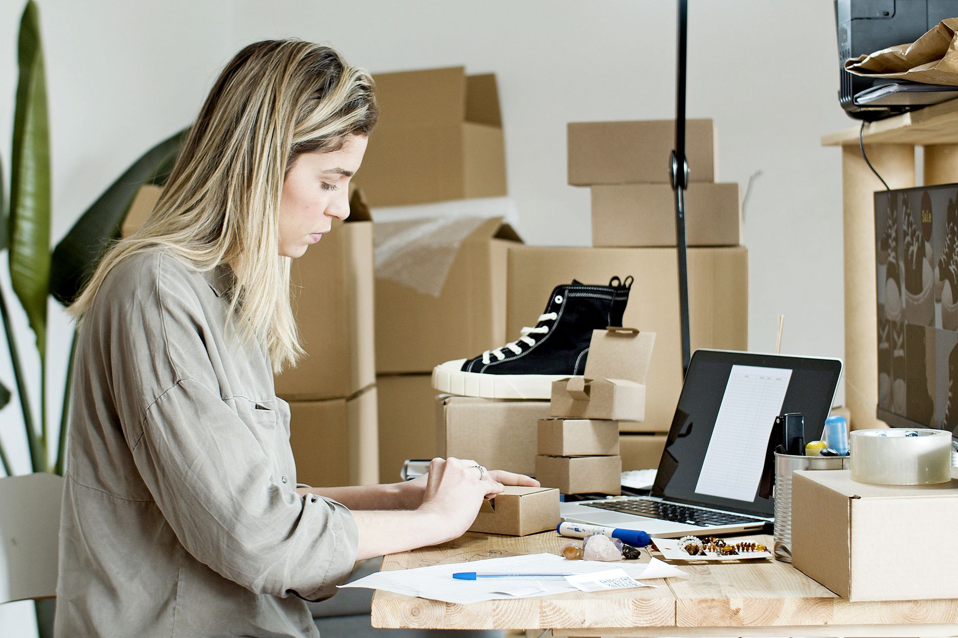 Woman at home with shopping packages and a laptop