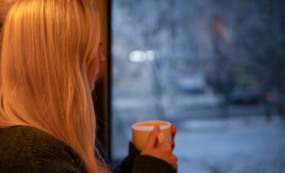 Woman sitting in bright morning light by a window