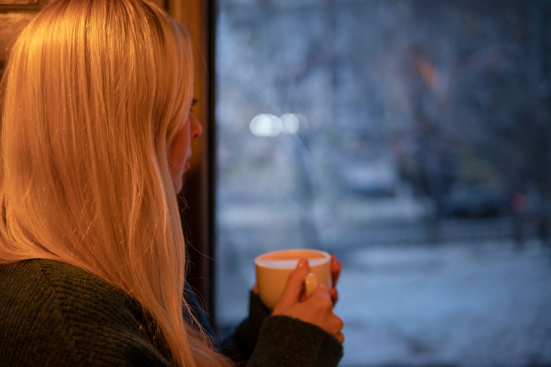 Woman sitting in bright morning light by a window