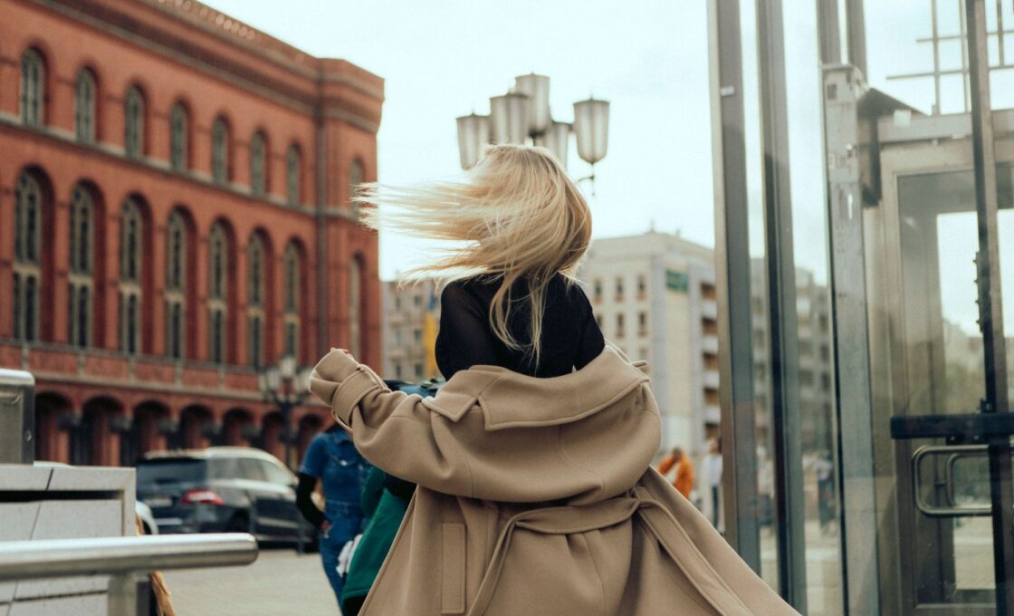 Woman exploring a European city street during shoulder season travel in early autumn