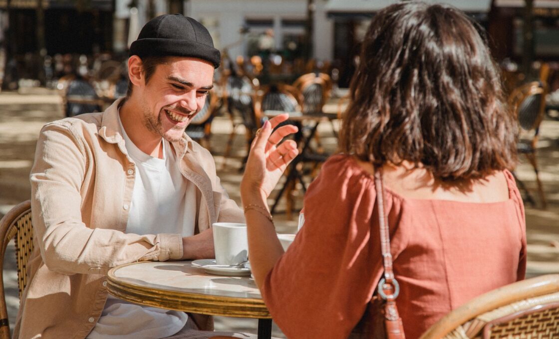 Two people talking on a first date at an outdoor cafe