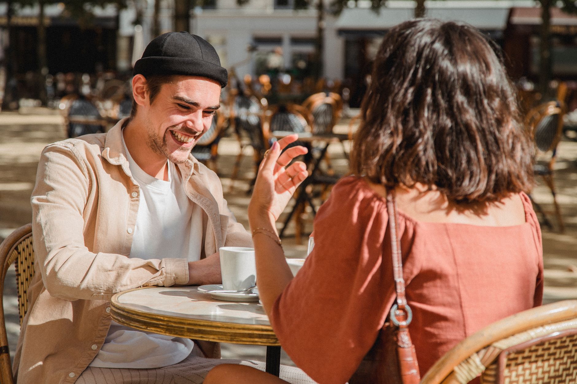 Two people talking on a first date at an outdoor cafe