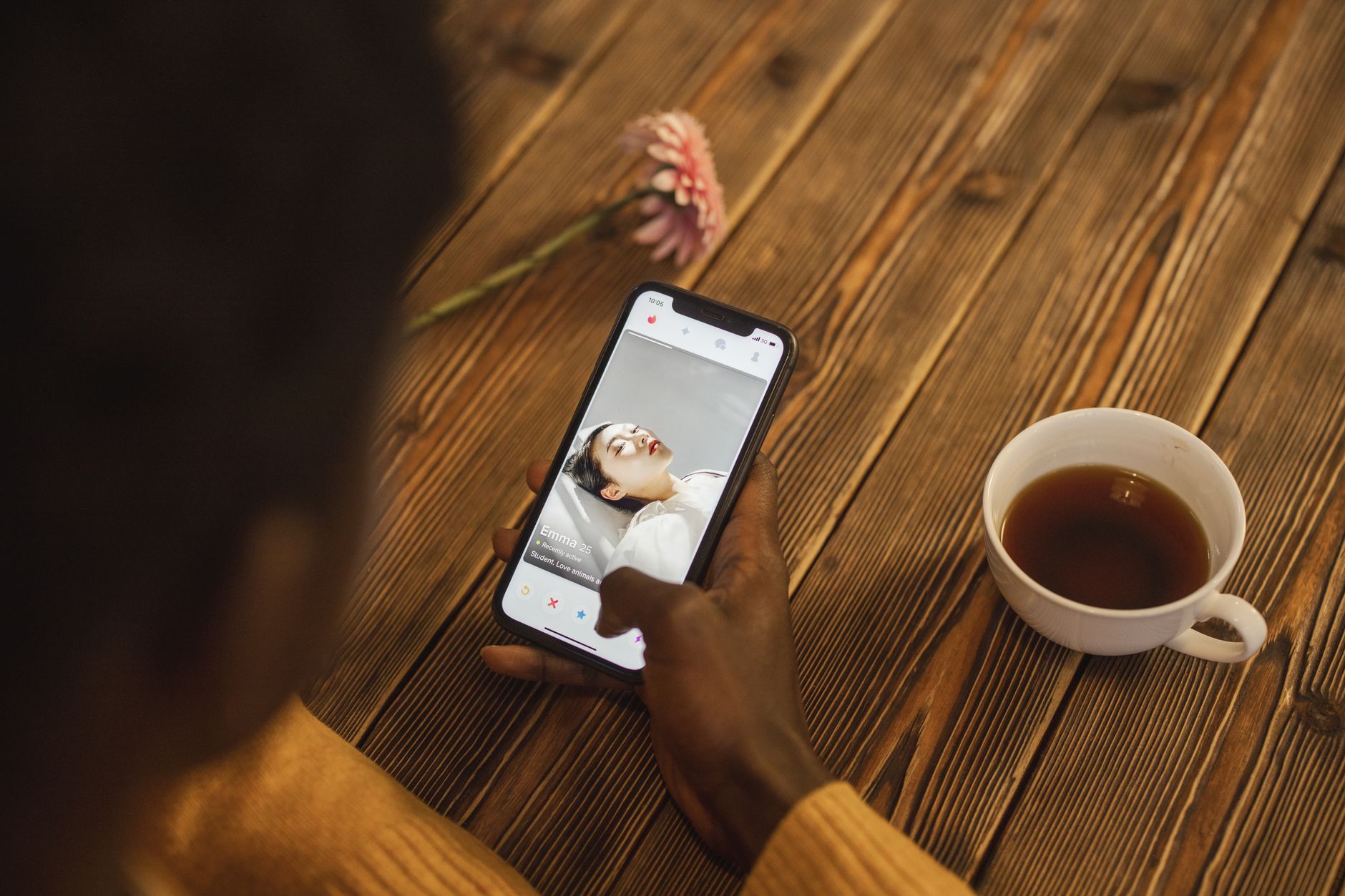 Woman looking at a dating app on her phone while sitting in a cafe