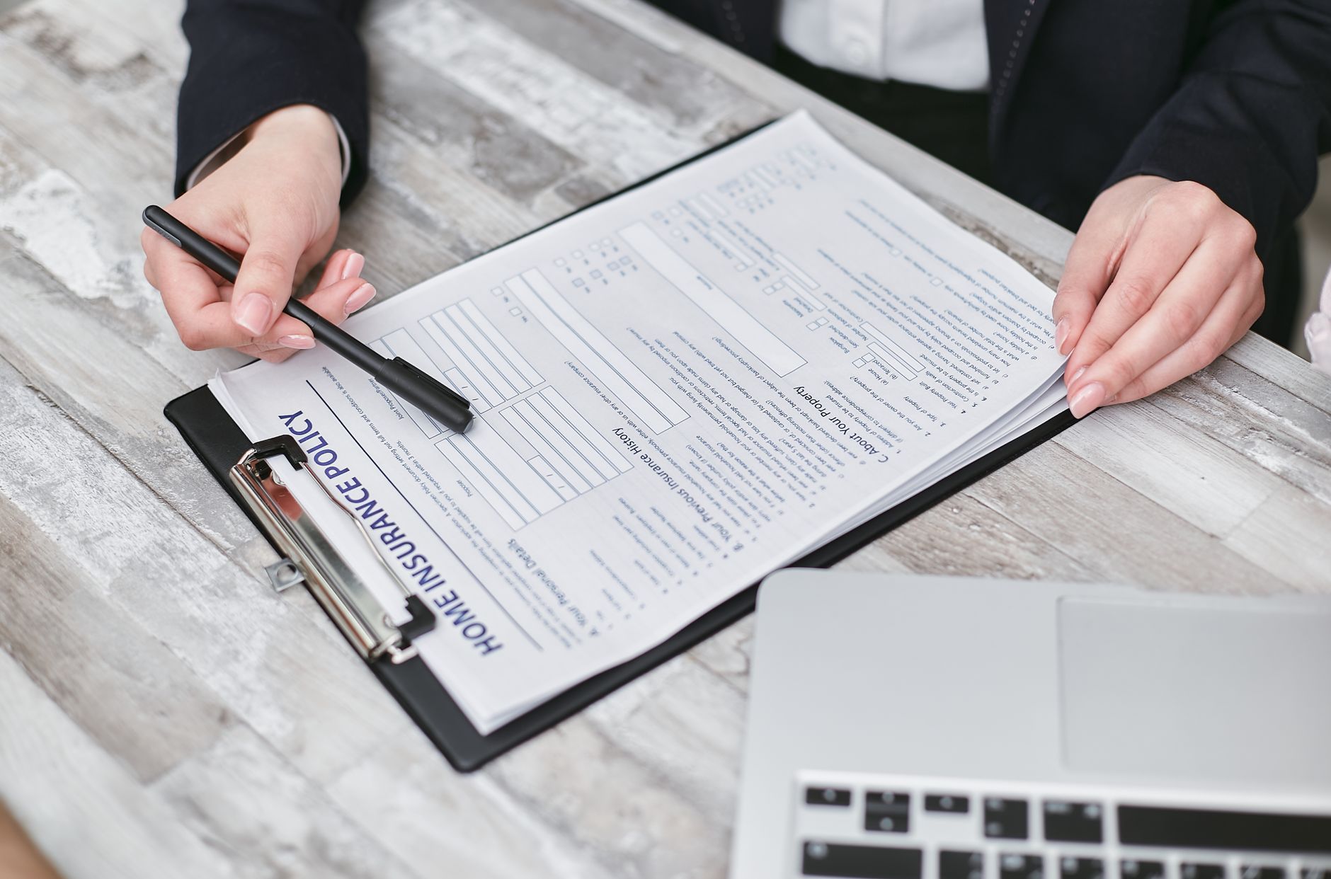 Hands reviewing a health insurance policy document during ACA open enrollment