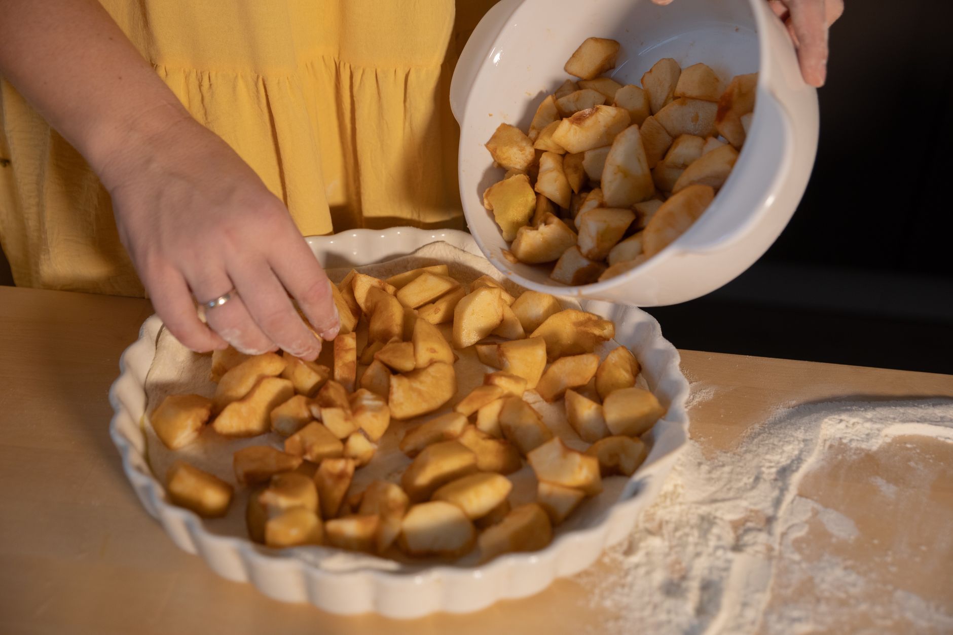 Woman preparing a homemade apple pie with fresh fall baking apples