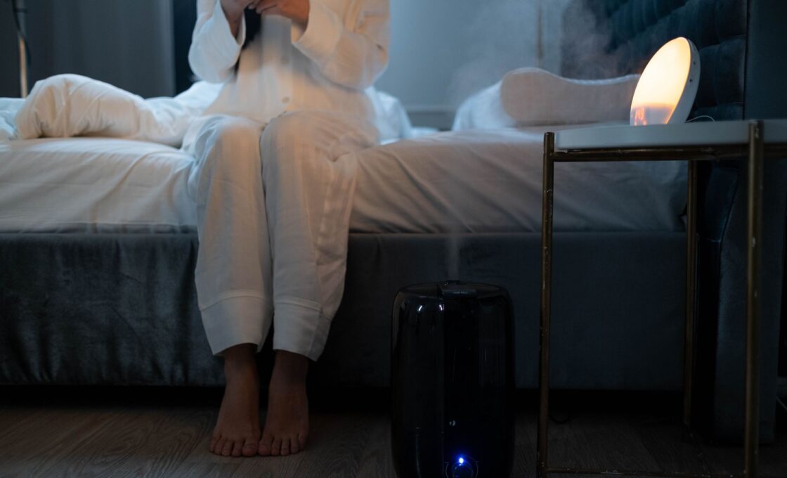 Humidifier misting in a bedroom during winter to raise indoor humidity