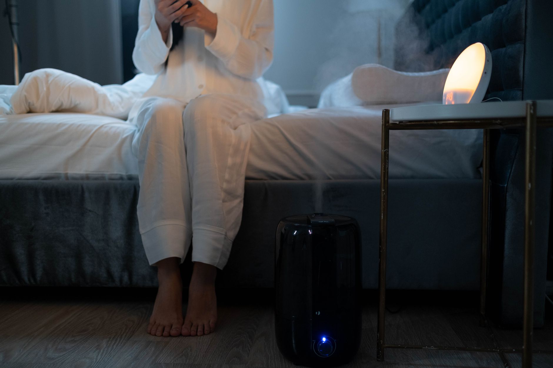 Humidifier misting in a bedroom during winter to raise indoor humidity