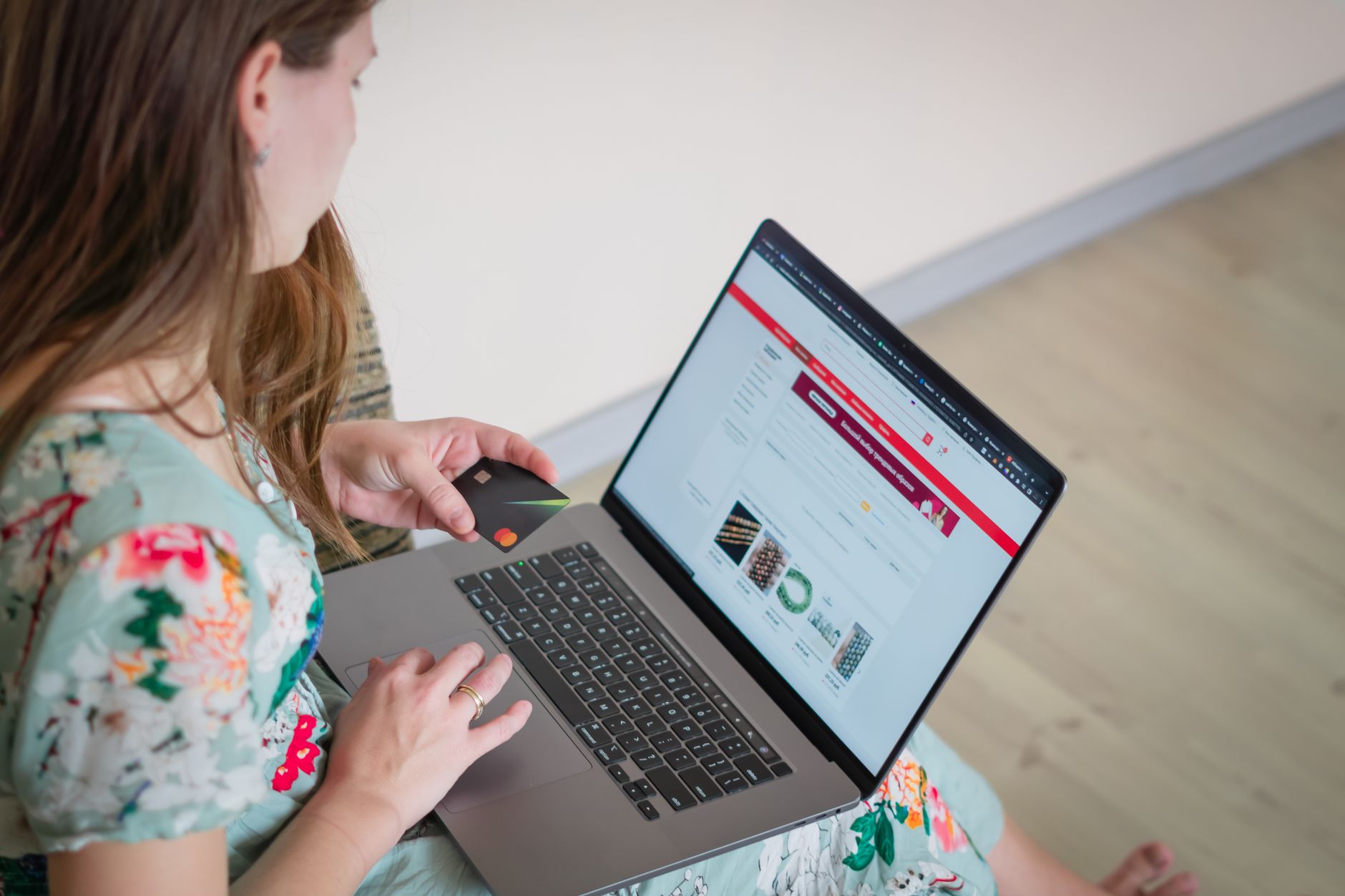 Woman holding a credit card while shopping online on a laptop, planning holiday buy now pay later payments