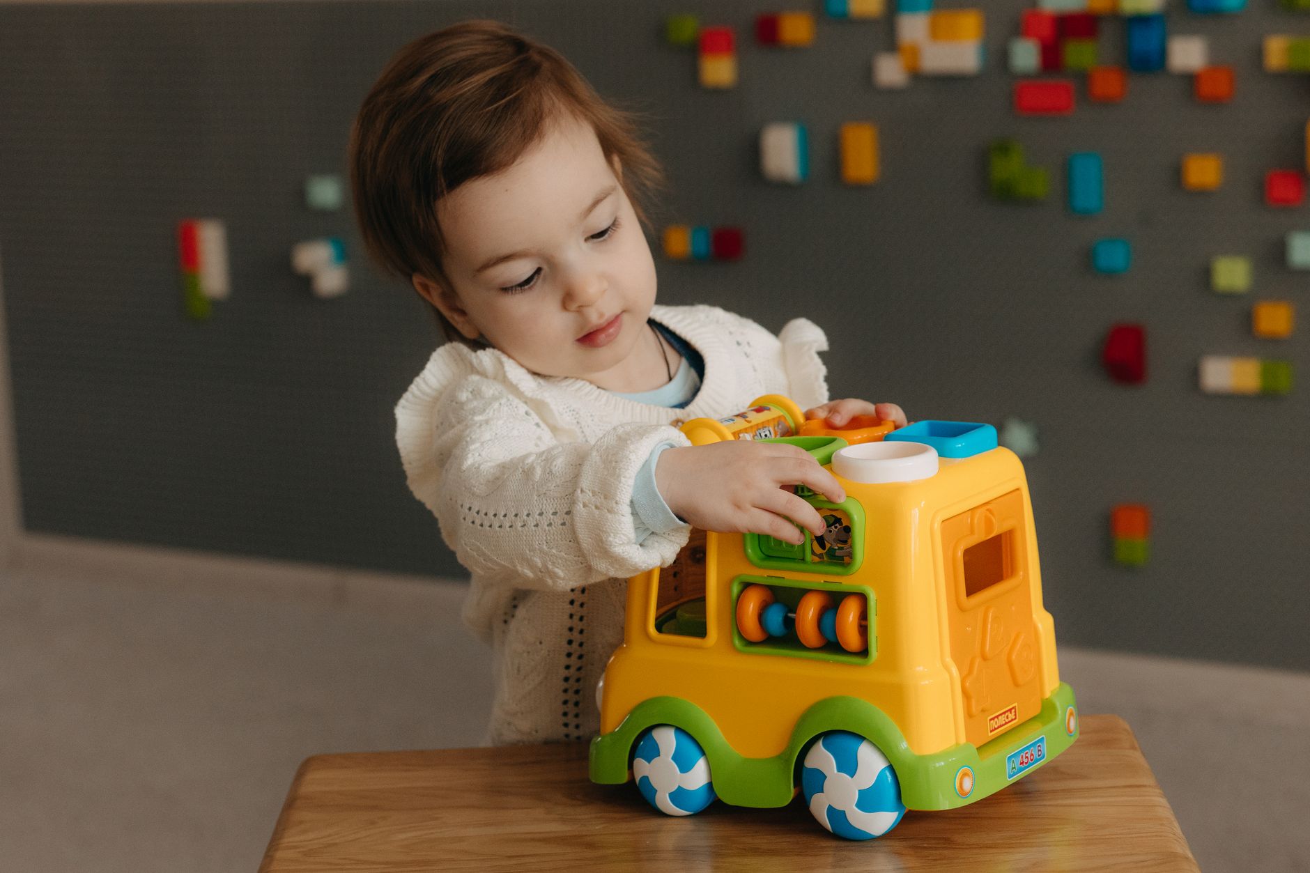 Young child playing with a toy truck indoors, the kind of daycare-age care a dependent care FSA or child care tax credit helps pay for
