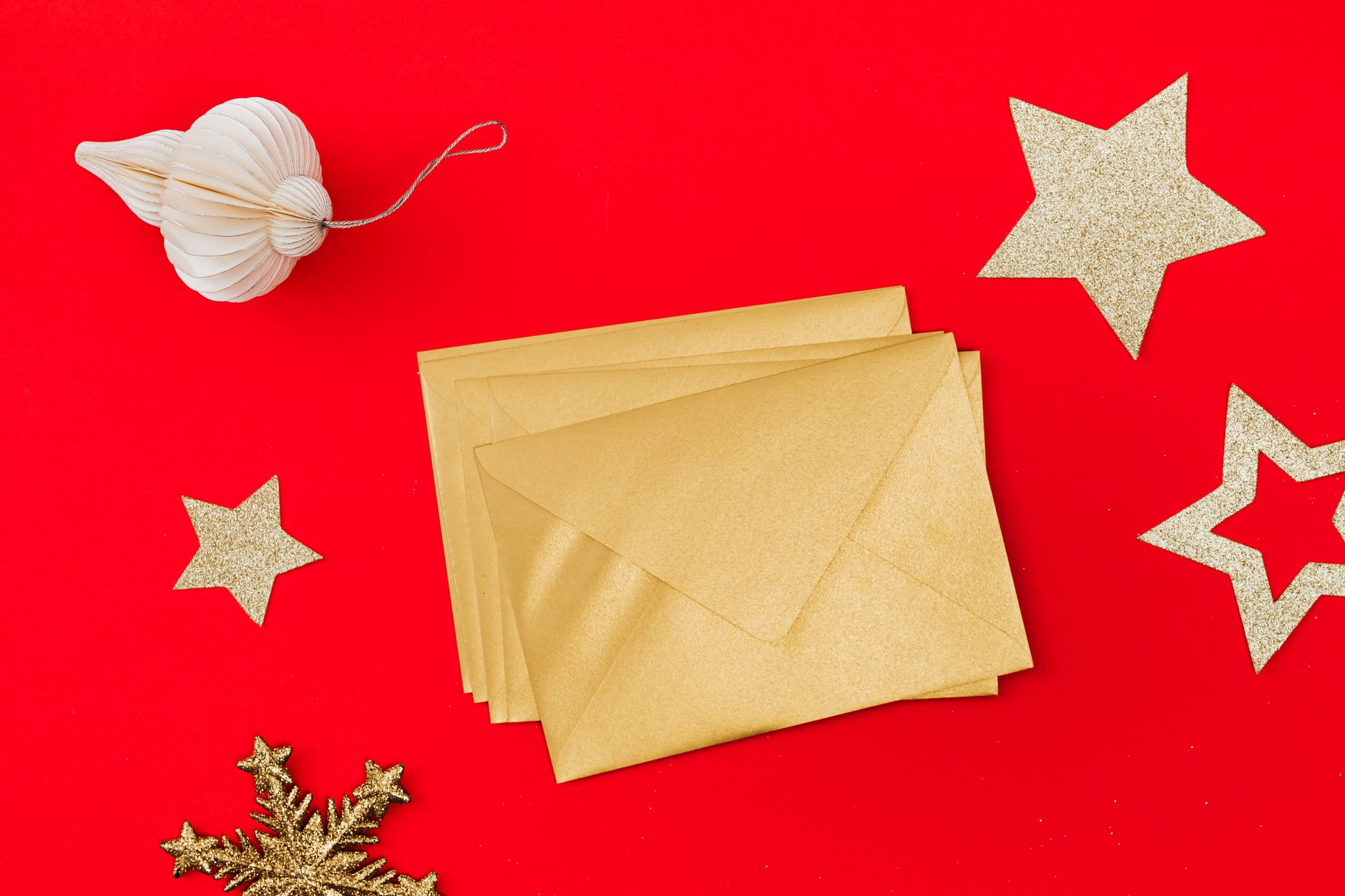 Gold holiday envelopes on a red background, ready for holiday tips