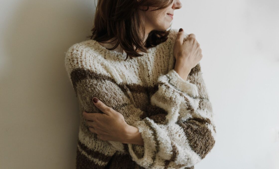 Woman wearing a soft knit sweater, illustrating how to tell good cashmere from pill-prone knits